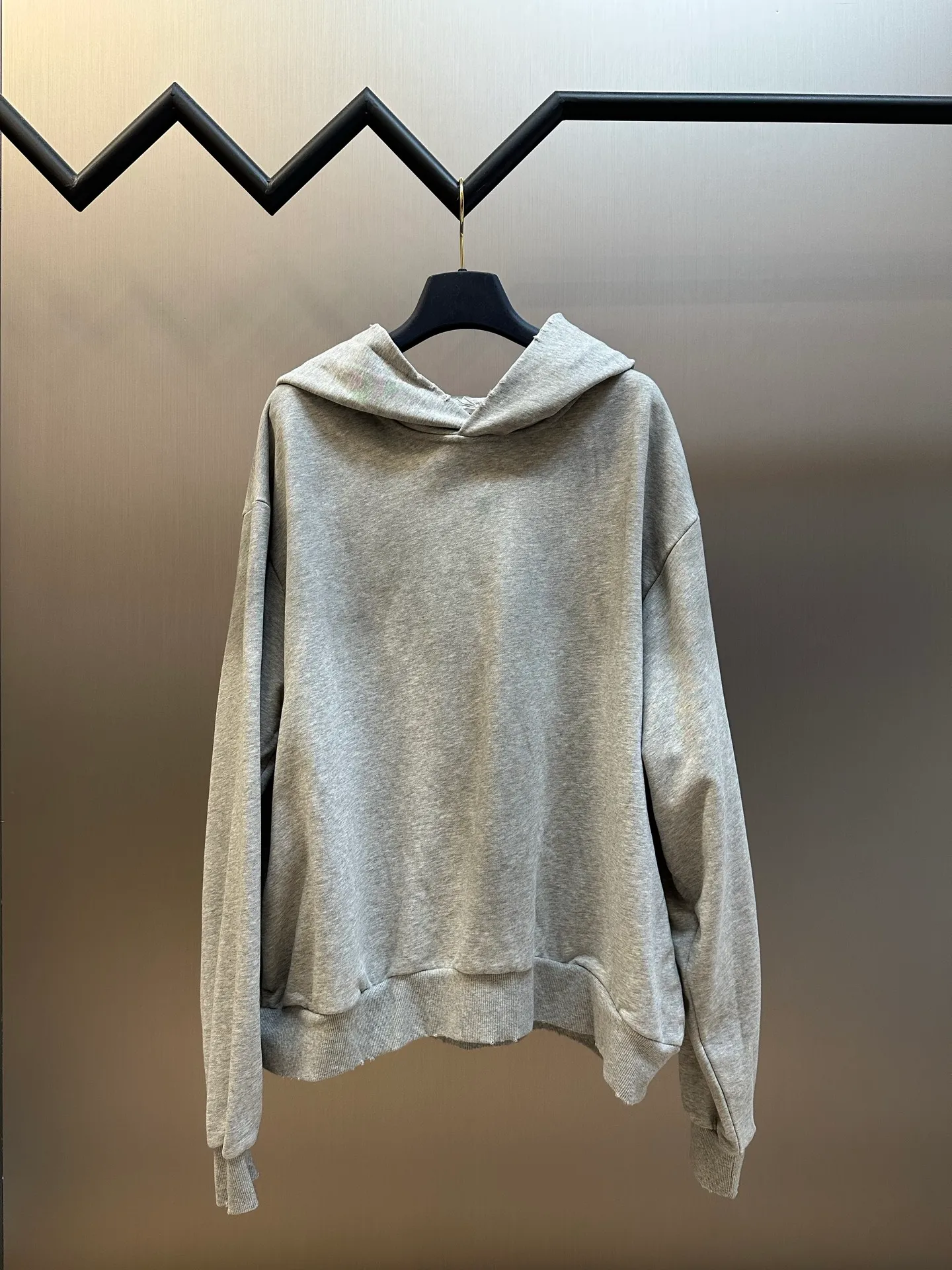 Ac spray-painted distressed logo hooded sweatshirt (grey) is made of custom air-oxygen soft cotton blend fabric, with a loose and relaxed silhouette. The raw edge hem outlines the casual lines of Retro. The Ac Studios STOCKHOLM logo on the back is quietly embellished, and the Classic logo is low-key engraved with the brand's genes. It exquisitely combines street luxury texture with Scandinavian minimalist aesthetics. Adopting the glue printing process, the chest printing is modified by the film screen three times. The glue liquid paint is used to print the pattern on the fabric and the fabric is baked to fix the printing pattern. The gradient distressed spray process sprays dyes of different colors on the surface of the fabric to achieve rich color changes under different lights and increase the visual layering. Many parts of the body of the garment are worn and worn at regular intervals, with manual brush marks added to add texture and depth to the surface of the garment to imitate the texture of natural wear and tear size: s m l xl